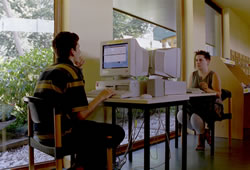 Foto: twee bezoekers raadplegen elk een computer in de bib.